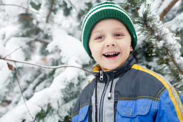 Happy little boy playing  on winter snow day.