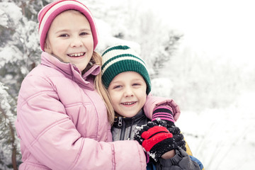 Happy little children playing  in winter snow day.
