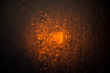 Fototapeta na wymiar The drops on glass bokeh background. Golden Sunset.