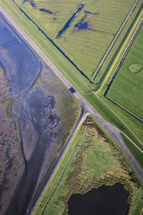 Aerial coastal view of the shore of Ameland Frisian Island with green fields, dike and sea, The Netherlands
