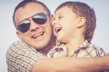 Father and son playing on the beach at the sunset time.