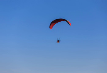 paraglider flying with paramotor on  blue sky  background