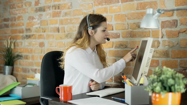 Call center agent sitting in the office and speaking with client
