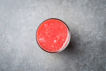Glass of fresh grapefruit juice on gray stone table