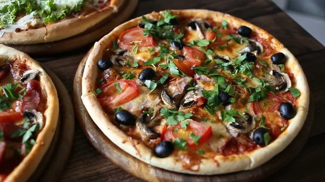 table with 3 ready pizza