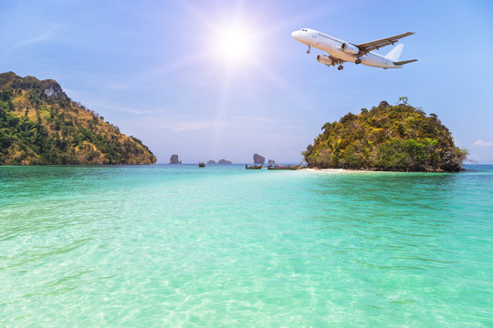 Fototapeta passenger airplane flying over above small island in tropical andaman sea. travel destinations concept