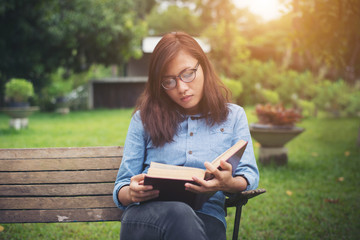 Hipster charming girl relaxing in the park while read book, Enjo