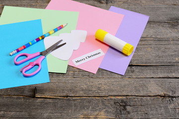 Making a Christmas greeting card. Step. Colored paper set, scissors, pencil, tree template, glue...