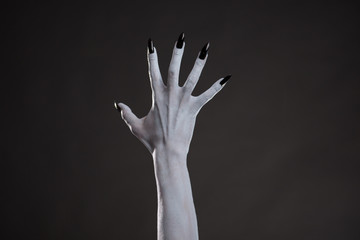 Spooky white hand with black nails