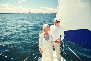 Fototapeta premium senior couple hugging on sail boat or yacht in sea