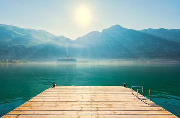 Early misty morning on the pier  with sea, Kotor city  and mountains on  background. Kotor bay. Montenegro