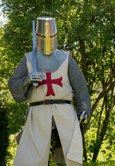 A person dresses up historically to mimic a knights templar in full armour