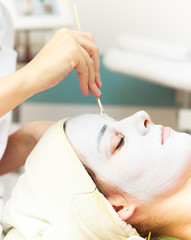 Facial mask.Beautiful young girl relaxing at spa ,getting skin treatment