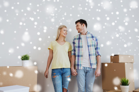 smiling couple with big boxes moving to new home