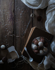 still life, vintage. candy, drapery, old books and a letter on  wooden table. black background, top view