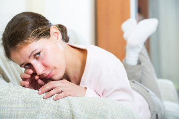 Sad young woman at home.