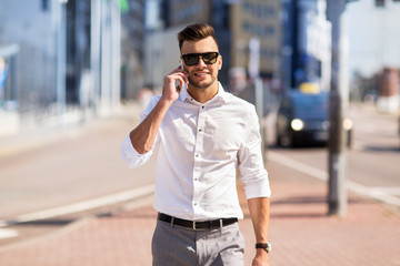 happy man with smartphone calling on city street