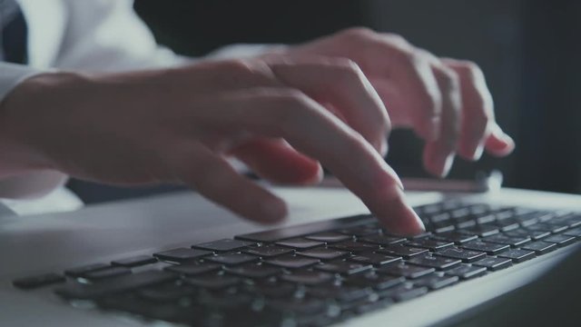 Extra close up of quckly typing work on computer. Typing text on a laptop computer keyboard. Black keyboard key. Networking. Typing message or email on laptop, searching in Internet