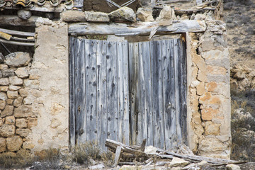 Door wood. Old rural gate. Large wooden door built in stone cassette.