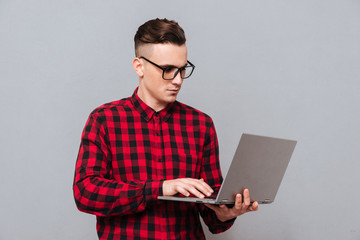Young hipster with laptop isolated
