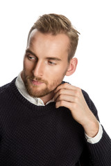 Attractive man sitting down wearing a pullover with a white shirt. White background.