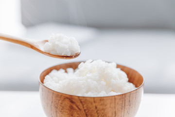 The wooden bowl is filled with rice.