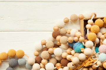 Knitted beads necklace on white wooden backroung