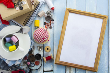 tools tailor spools threads buttons needle sewing blue white rusty vintage wooden background
