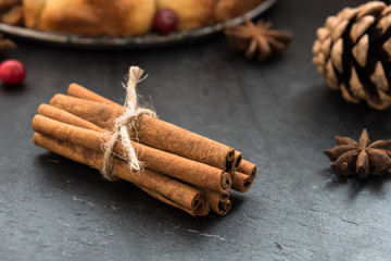 Anise, cinnamon, cranberries on black table