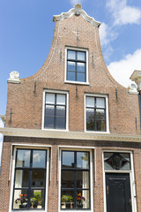 Fototapeta na wymiar Typical Dutch red brick gabble house facade, The Netherlands