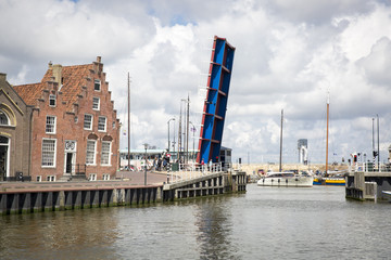 Fototapeta premium Noorderhaven canal with boats, open bridge and houses in historic old town of Harlingen, Friesland, Netherlands