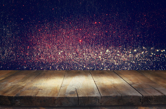 old wooden table in front of glitter lights background