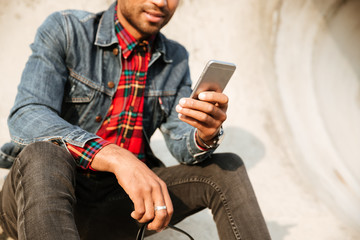 Cropped picture of african man chatting by his phone.