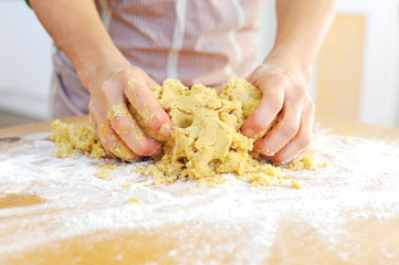 Frau knetet Teig mit den Händen, zum Backen