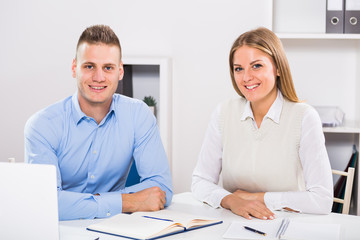 Obraz premium Portrait of businesswoman and businessman sitting in office and working together. 