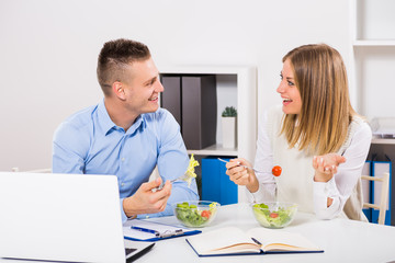 Businesswoman and businessman are having lunch break and talking.
