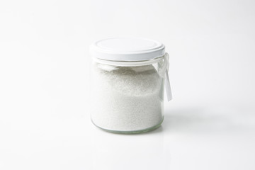 food or lifestyle, glass jar with salt or bath salt isolated in white background