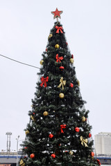 Christmas tree with garland and a star, decorated with toys