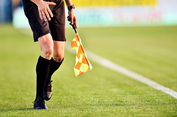 Obraz premium Soccer referee with flag on the sideline