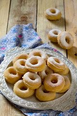 Donuts with powdered sugar on a wooden background. The concept o