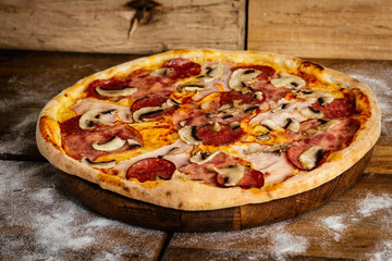 Pizza with corn, sausages and mushrooms on wood background 