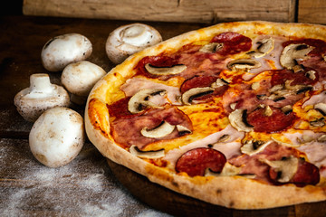 Pizza with corn, sausages and mushrooms on wood background with ingredients