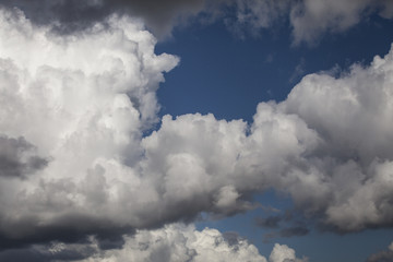 White fluffy storm clouds in blue sky