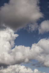 White fluffy storm clouds in blue sky