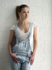 Obraz premium young caucasian woman in blue denim overalls