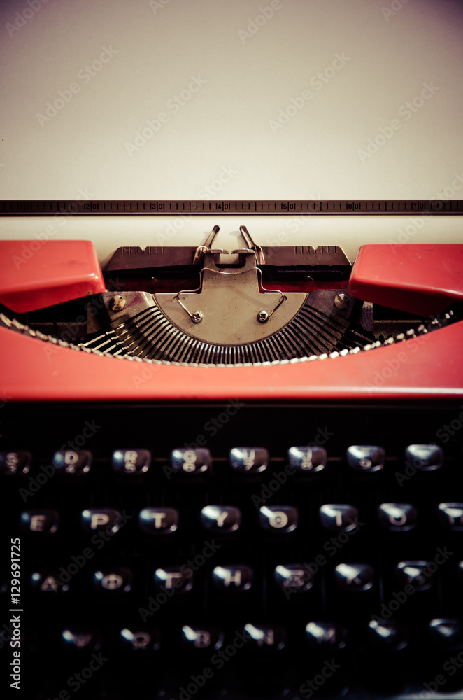 Fototapete close up of the letters on an old typewriter with paper. retro style.