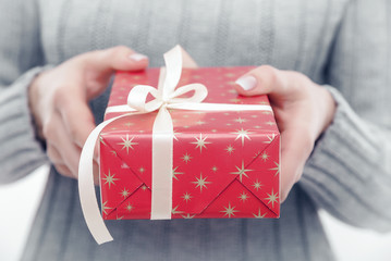 Female hands holding a gift box.