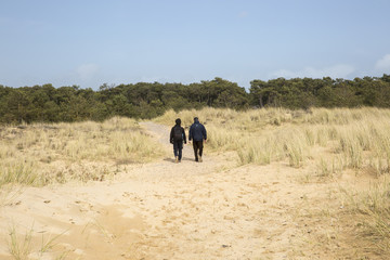 Two men walking in the dunes on a beach of L'aiguillon sur Mer, Vendee, France