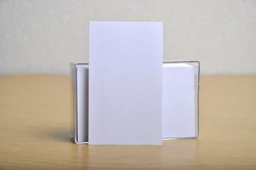 blank mockup business card for branding and logo print lean on blank  stack of business card in it case. potrait style. - 129696518