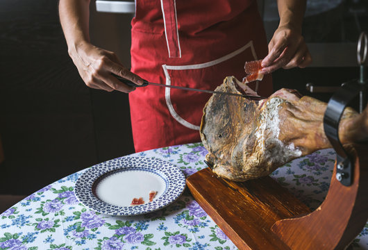 Unrecognizable woman slicing sliced ham